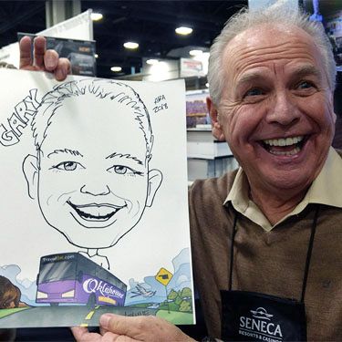 man holding his caricature